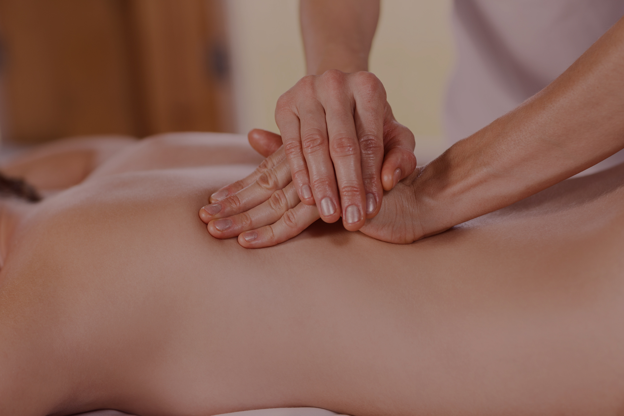 hands massaging back of woman